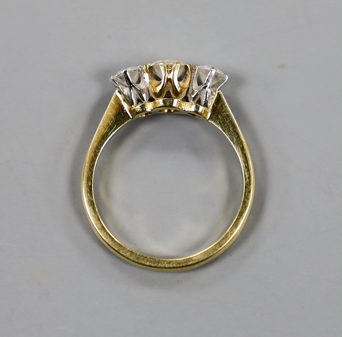 A modern 18ct gold and three stone set diamond ring, size K/L, gross weight 3 grams.